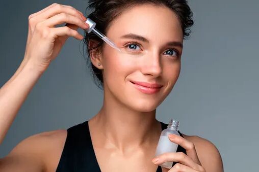 La fille utilise le sérum pour le rajeunissement